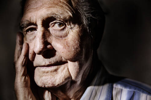 Portrait of senior man with hand on face, close-up - JATF01174