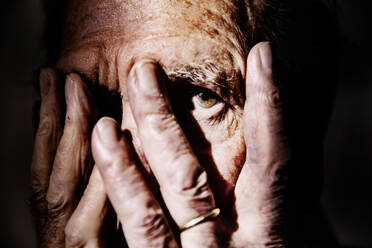 Älterer Mann, der sein Gesicht mit den Händen bedeckt, Nahaufnahme - JATF01175