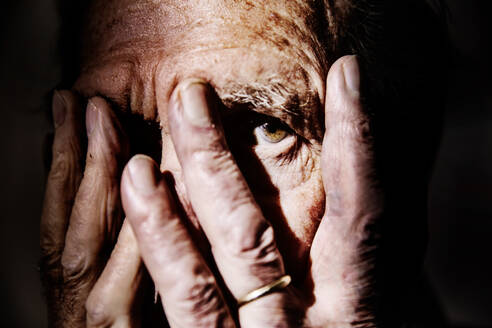 Senior man covering face with hands, close-up - JATF01175