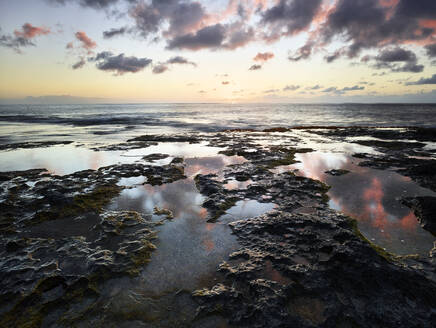 Blick auf das Meer und den Himmel vom felsigen Strand des Ka'ena Point State Park bei Sonnenuntergang - CVF01281