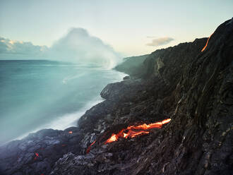 Lava, die aus dem Pu'u O'o' im Meer im Hawaii Volcanoes National Park gegen den Himmel fließt - CVF01296