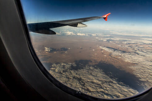 Flugzeugflügel über der Wüste durch ein Fenster gesehen - NGF00520