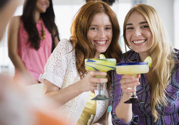 Frauen, die sich gegenseitig mit Margaritas anstoßen - BLEF10213