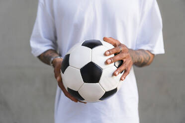 Young man's hands holding football, close-up - MGIF00562