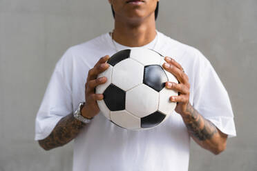 Young man's hands holding football, close-up - MGIF00563