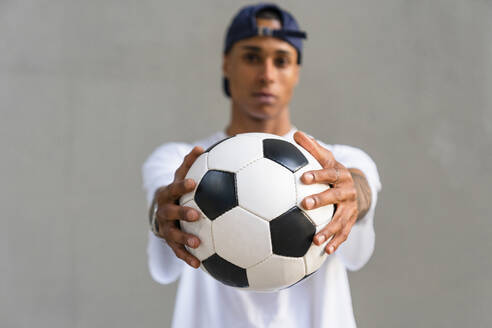 Die Hände eines jungen Mannes halten einen Fußball, Nahaufnahme - MGIF00564