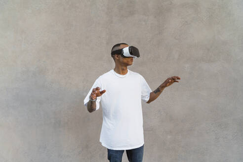 Tätowierter junger Mann mit Virtual-Reality-Brille - MGIF00583