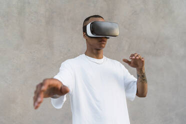 Tätowierter junger Mann mit Virtual-Reality-Brille - MGIF00585