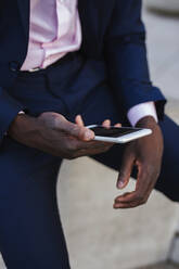 Close up of a young businessman using his smartphone - LJF00469