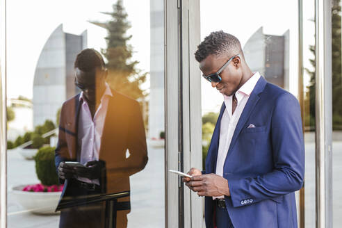 Young businessman using his smartphone outside - LJF00473