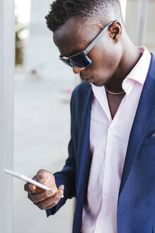 Young businessman using his smartphone outside - LJF00475