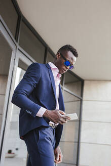 Young businessman using his smartphone outside - LJF00476