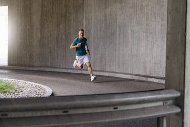 Sportlicher Mann sprintet auf einer Straße - DIGF07490