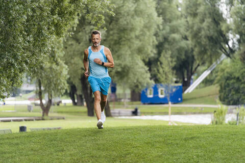 Sportlicher Mann beim Joggen in einem Park, lizenzfreies Stockfoto