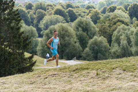 Sportlicher Mann beim Joggen in einem Park, lizenzfreies Stockfoto