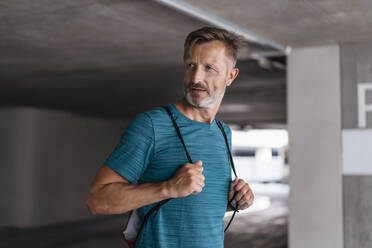 Portrait of a sporty man carrying a pouch - DIGF07523