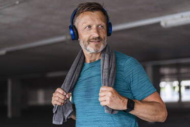 Sportlicher Mann mit Kopfhörern nach dem Training - DIGF07529