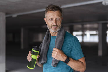 Sportlicher Mann mit Trinkflasche nach dem Training - DIGF07530