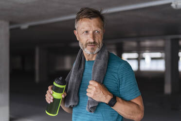 Sporty man with drinking bottle after workout - DIGF07530
