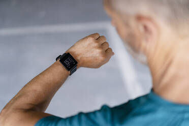 Sportlicher Mann überprüft seine Smartwatch - DIGF07532