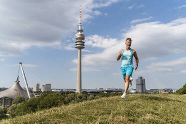 Sportlicher Mann beim Joggen in einem Park - DIGF07548