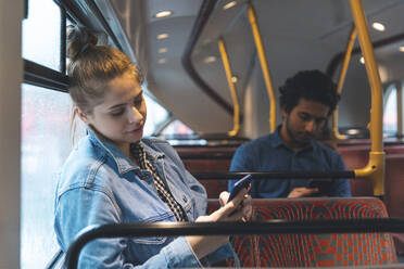 Mann und Frau benutzen Mobiltelefone im Bus - WPEF01578