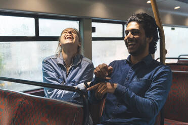 Junges Paar reist mit dem Bus an einem regnerischen Tag und hat Spaß, London, UK - WPEF01582