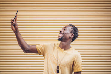 Lachender Mann macht Selfie mit Smartphone - OCMF00485