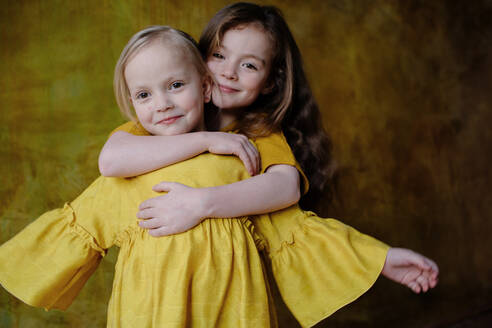 Portrait of smiling girl hugging her little sister - OGF00068