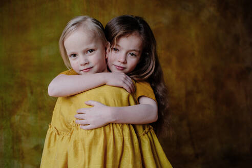 Portrait of smiling girl hugging her little sister - OGF00069