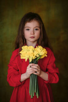 Portrait of little girl in red dress with bunch of daffodils - OGF00074