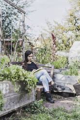 Young woman relaxing in urban garden - VGPF00058