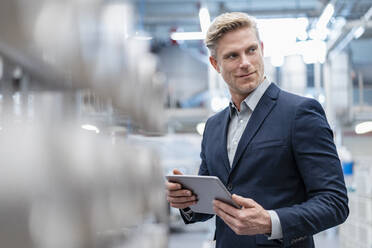 Geschäftsmann mit Tablet in einer modernen Fabrik - DIGF07564