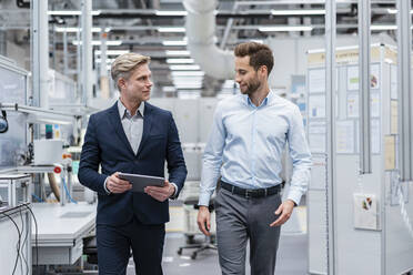 Two businessmen with tablet talking in a modern factory - DIGF07569