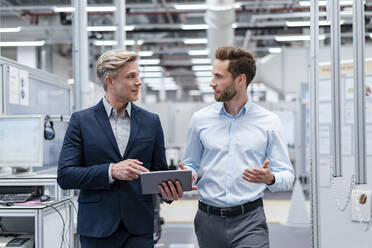 Two businessmen with tablet talking in a modern factory - DIGF07570