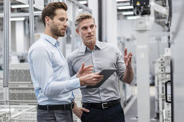 Two businessmen with tablet talking in a modern factory - DIGF07585