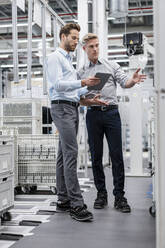 Two businessmen with tablet talking in a modern factory - DIGF07586