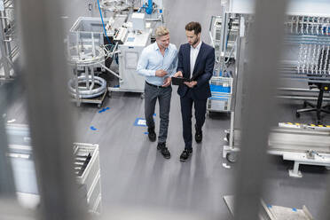 Two businessmen with clipboard talking in a factory - DIGF07592