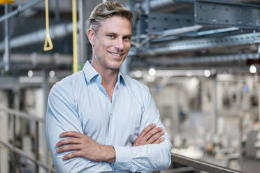 Portrait of a confident businessman in a factory - DIGF07596