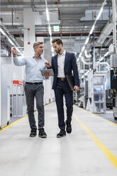 Two businessmen with tablet talking in a modern factory - DIGF07601