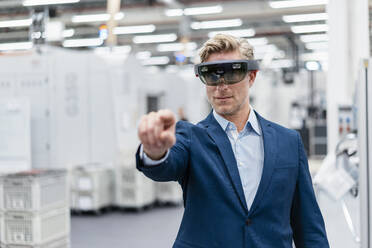 Geschäftsmann mit AR-Brille in einer modernen Fabrik - DIGF07620