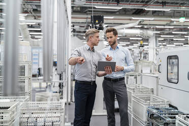 Two businessmen with tablet talking in a modern factory - DIGF07652