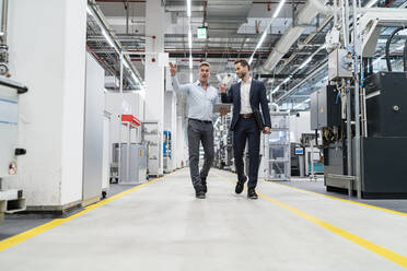 Two businessmen with tablet talking in a modern factory - DIGF07661