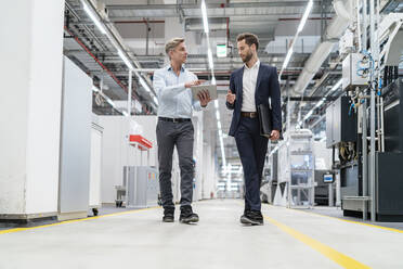 Two businessmen with tablet talking in a modern factory - DIGF07662