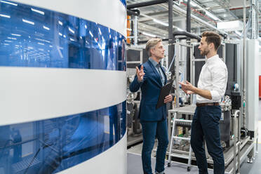 Two businessmen talking in a modern factory - DIGF07696