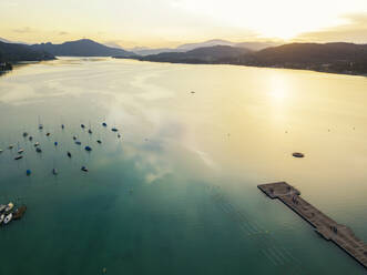 Luftaufnahme von Steg und Booten im Wörthersee gegen den Himmel bei Sonnenuntergang - JUNF01663