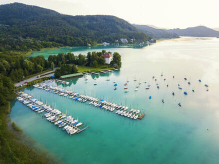 Aerial view of boats moored by jetty in Woerthersee at harbor against sky during sunset - JUNF01664