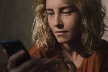 Portrait of blond young woman using cell phone - GCF00298