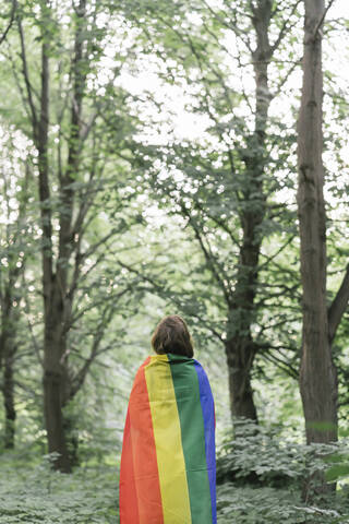 Rückansicht einer mit einer Regenbogenflagge bedeckten Frau, lizenzfreies Stockfoto