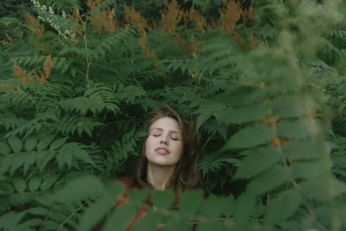 Face of young woman amidst plants - AHSF00598